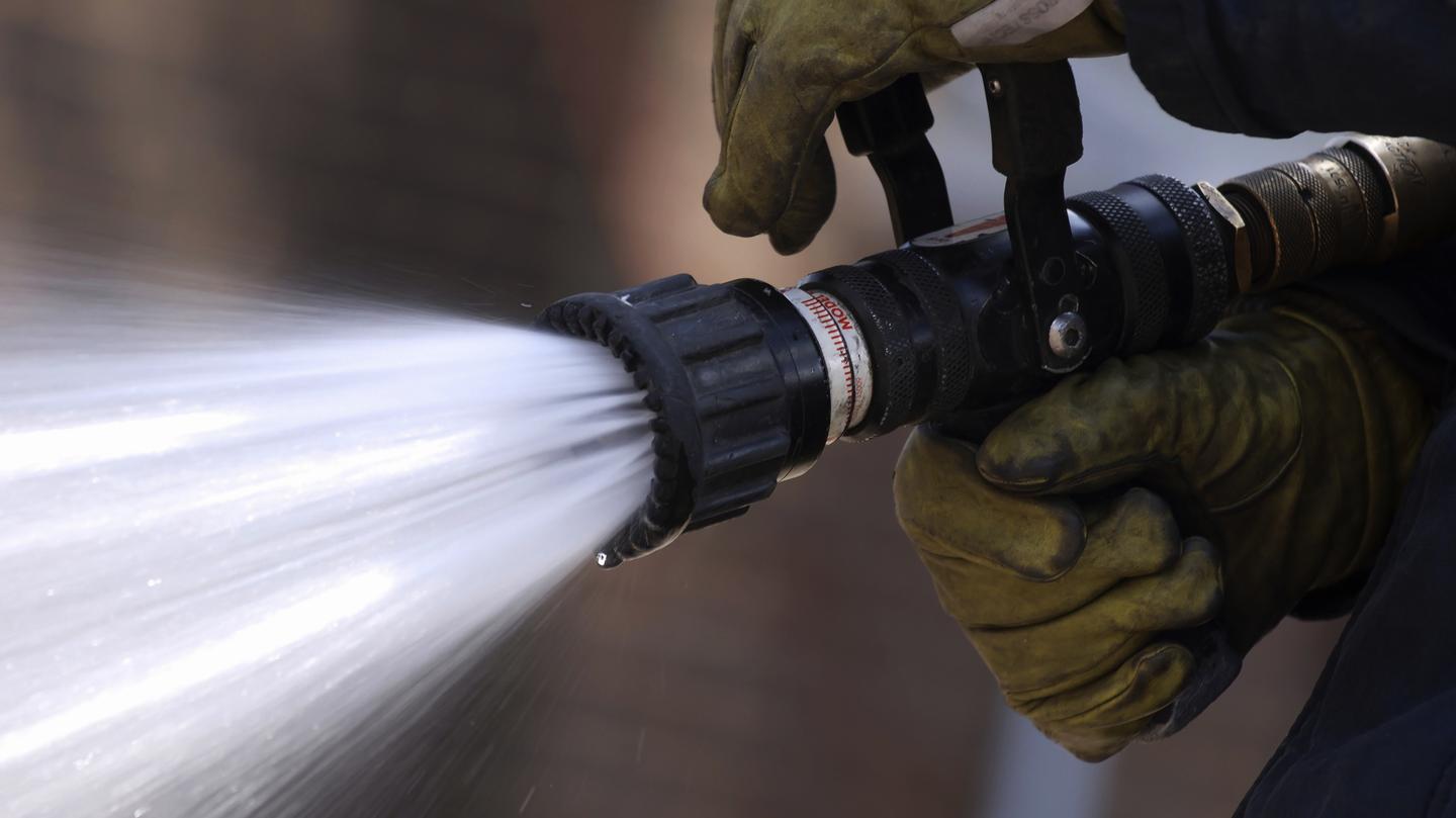 Ein Feuerwehrschlauch der Wasser spritzt