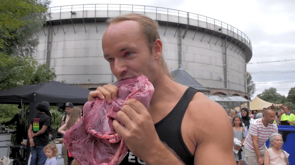 En mand åd et stort stykke råt kød for at provokere under en vegansk festival
