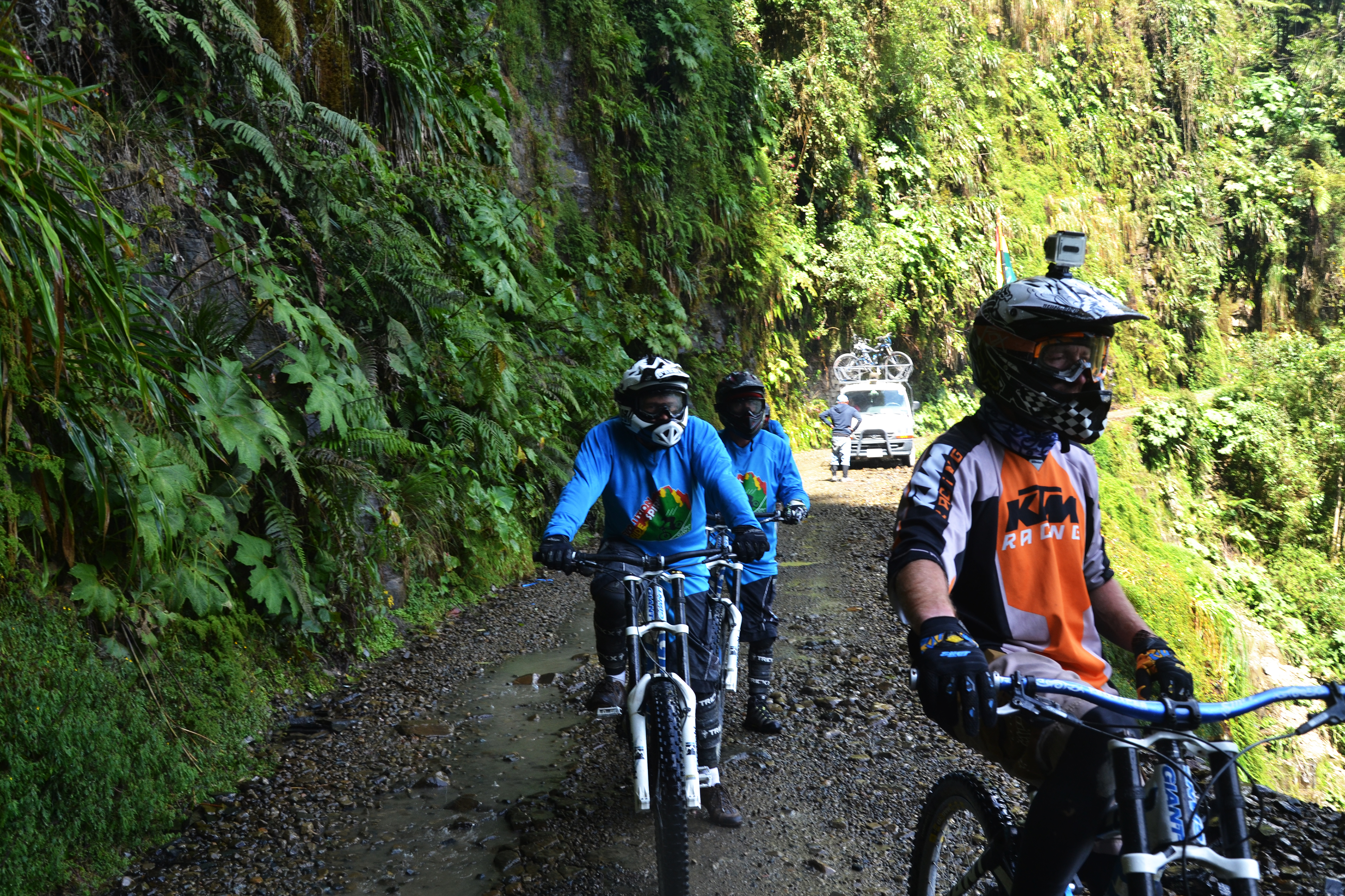 Drei Mountainbiker und das Begleitfahrzeug in Bolivien