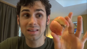 Man holds up a salak fruit to camera