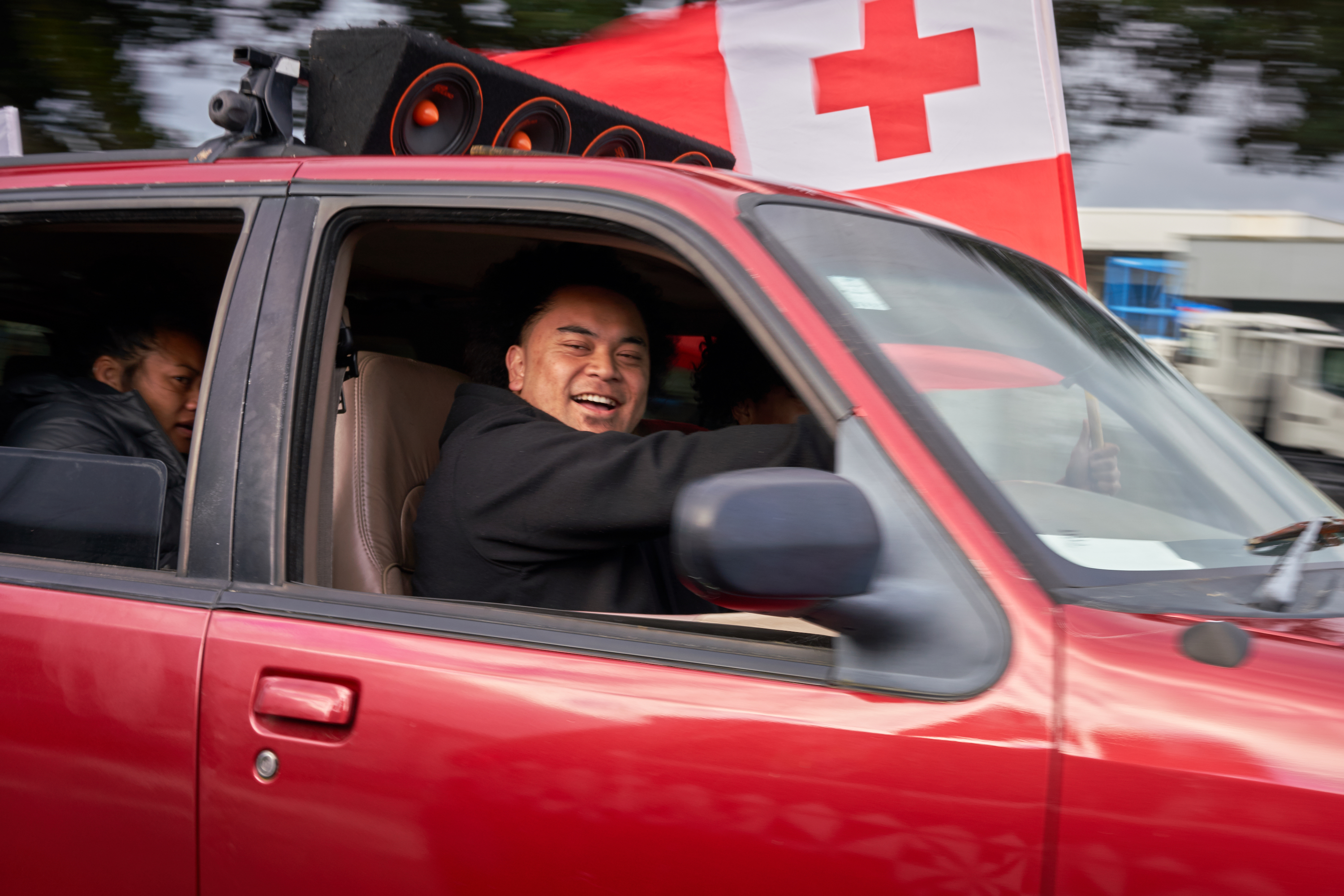 Tongan fan driving with Tongan flag