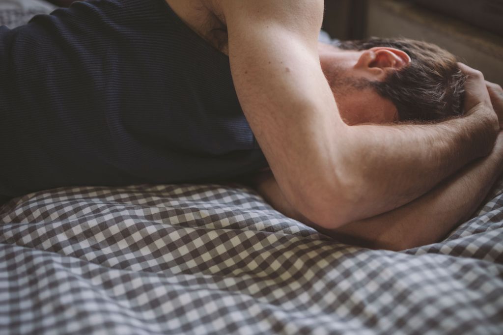 Depressed guy in bed.