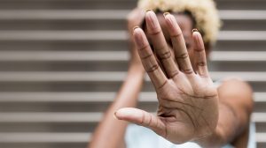 eine Frau hält ihre Hand in die Kamera und verdeckt ihr Gesicht