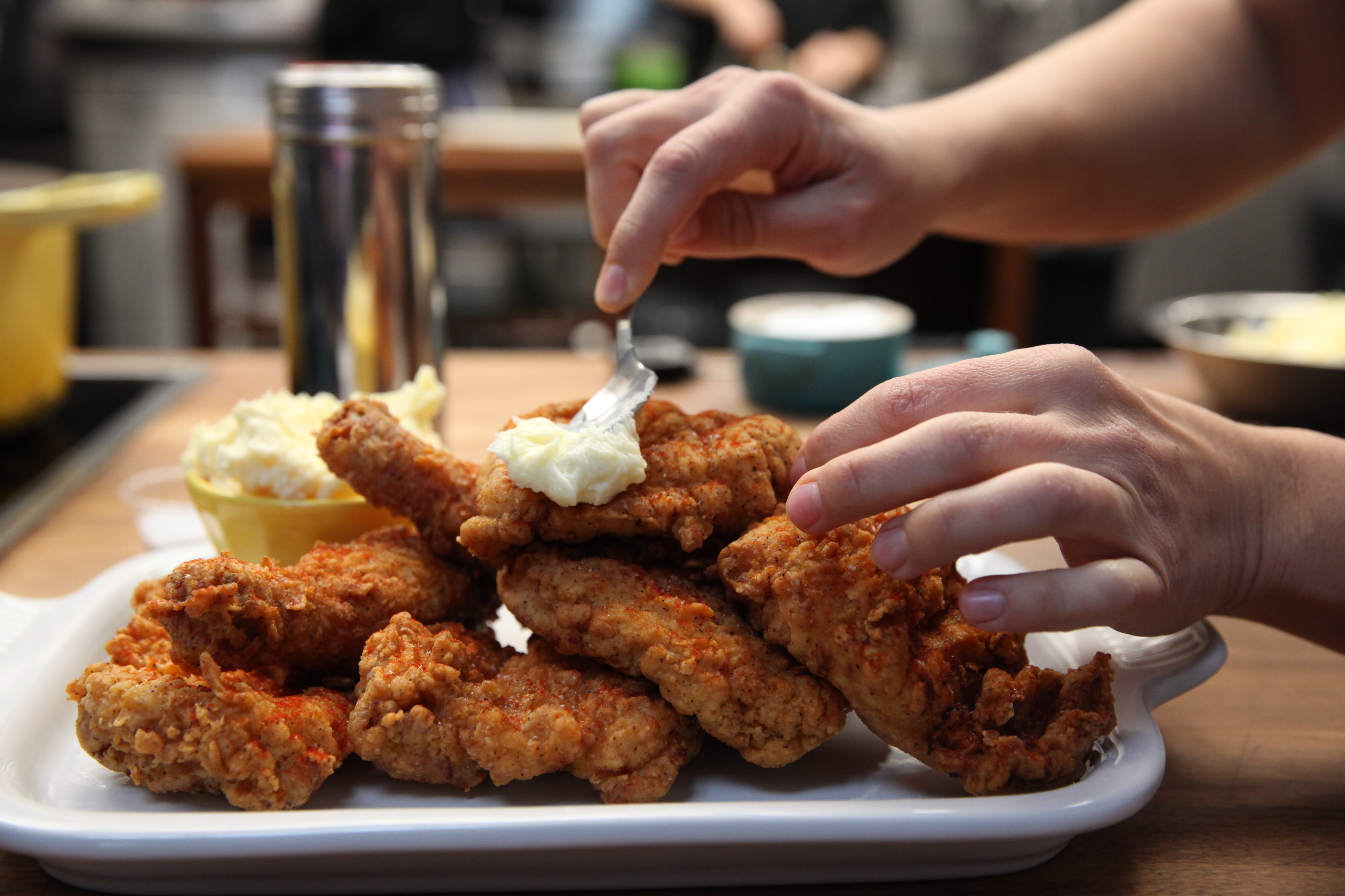 putting honey butter on fried chicken