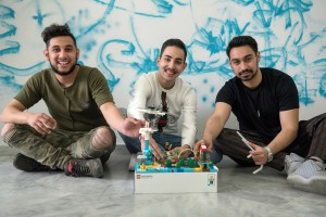 The Roma robotics team behind one of their creations.