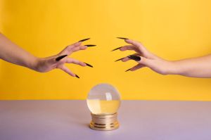 A pair of hands lingering above a crystal ball