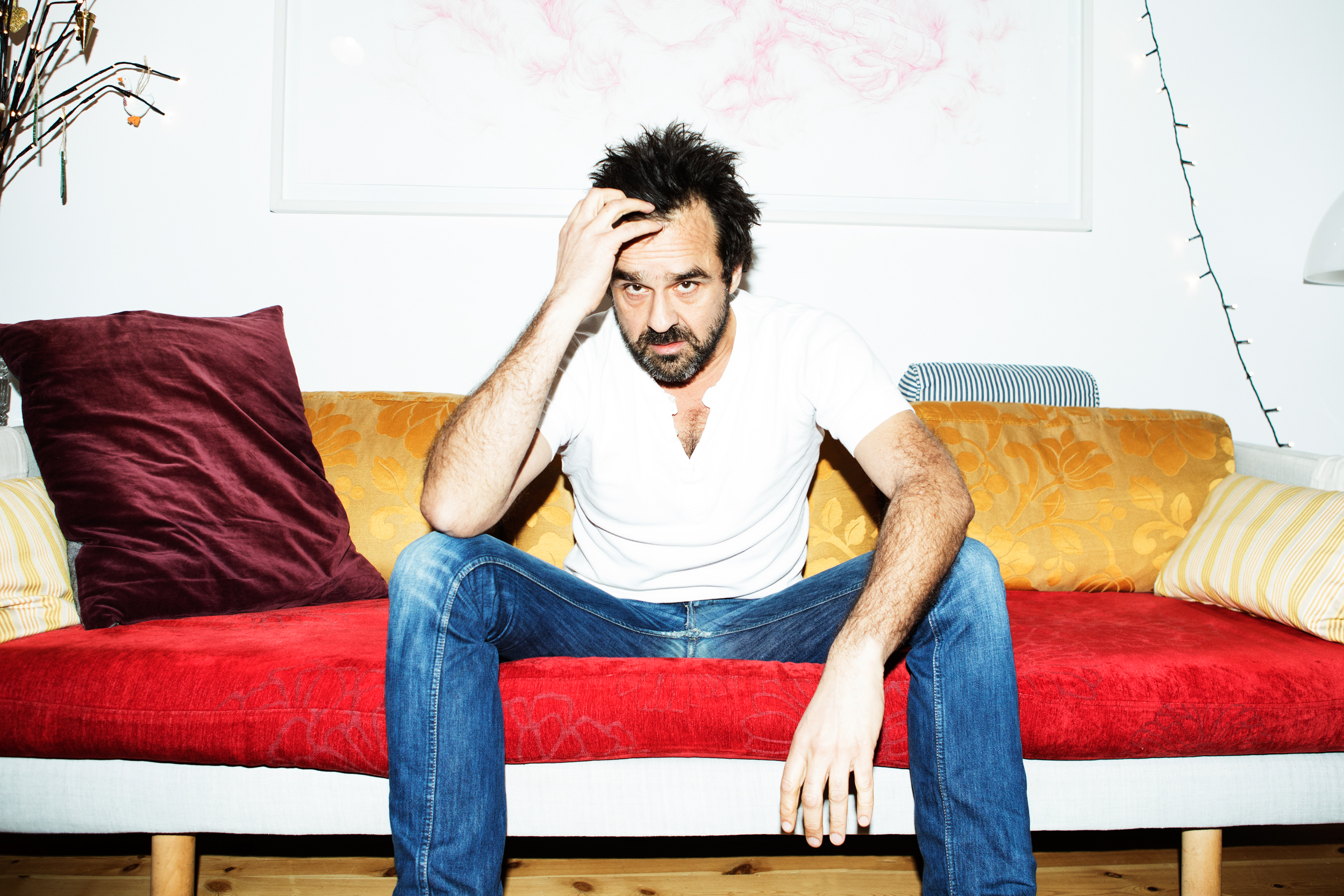 Hassan Preisler sidder i sin sofa og ser vred ud