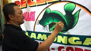 Hartono, pelukis spanduk pecel lele Lamongan legendaris