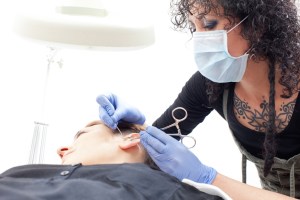 Vrouw krijgt een daith piercing tegen migraine gezet