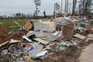 More than 100 rescuers are digging through rubble in rural Alabama in search of victims of a half-mile wide tornado that killed at least 23 people over the weekend and destroyed mobile homes.