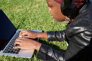 black woman on computer in the park