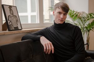 Der Autor sitzt auf einer Couch und guckt ernst, er erzählt über seine Erfahrungen mit Psychotherapie