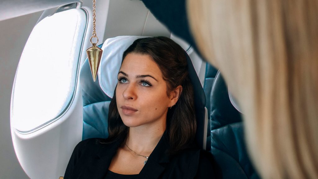 Eine Frau lässt sich im Flugzeug hypnotisieren