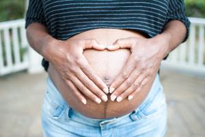 Black pregnant woman holds stomach