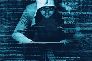 A blue tinted image of a man wearing a hoodie and glasses slouching over a laptop, with superimposed lines of code around the image