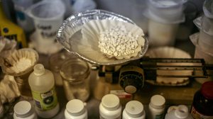 ein Drogenlabor mit Pillen und Flaschen und Plastikdosen, wo Kokain, Crystal und Co. gestreckt werden