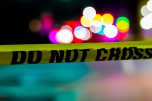 Yellow tape that reads "do not cross" at a crime scene.