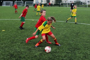 Eine Fußballspielerin des SB Frankfort im Zweikampf mit einem Jungen
