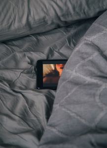 Tablet on bed showing porn