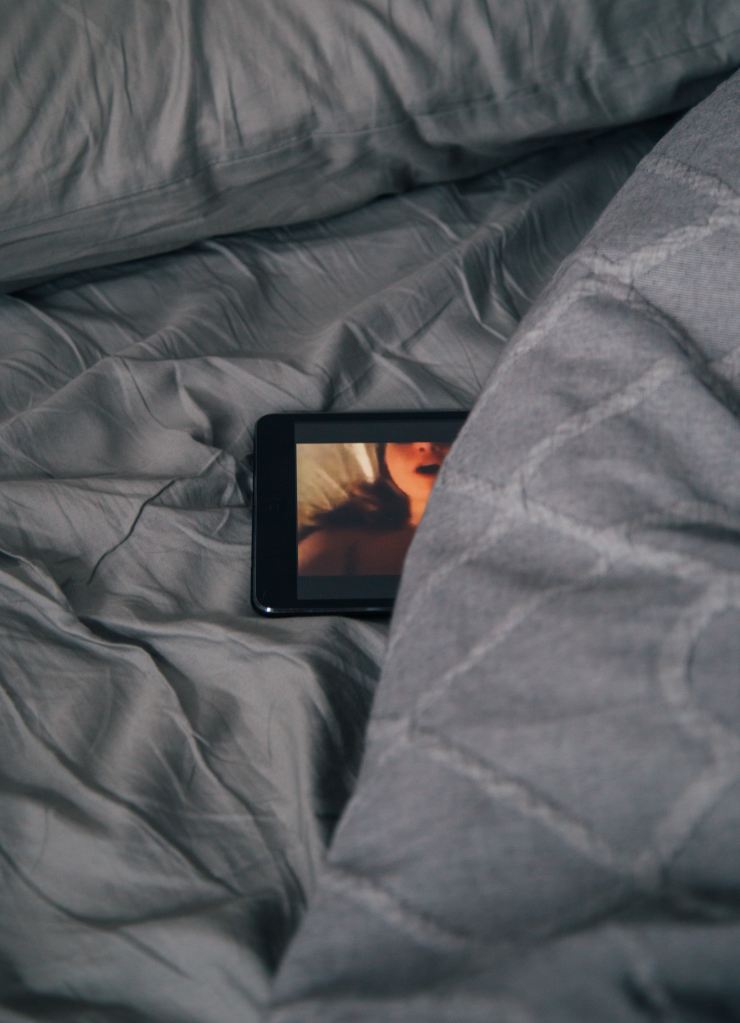 Tablet on bed showing porn