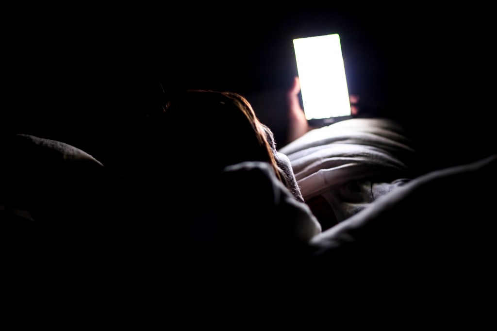 Person reading text messages in bed