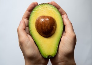 avocado half in hands