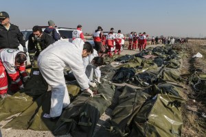 Rescue workers and forensic investigators inspect the bodies of victims of a Ukrainian plane crash