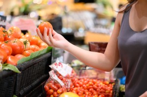 woman touching tomato food supermarket groceries