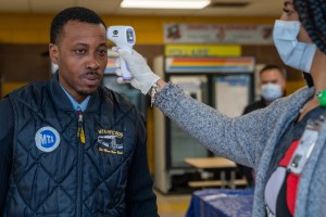John Tolbert an MTA bus driver has his temperature taken before starting his shift at the West Farms Bus Depot on April 10, 2020 in New York City.