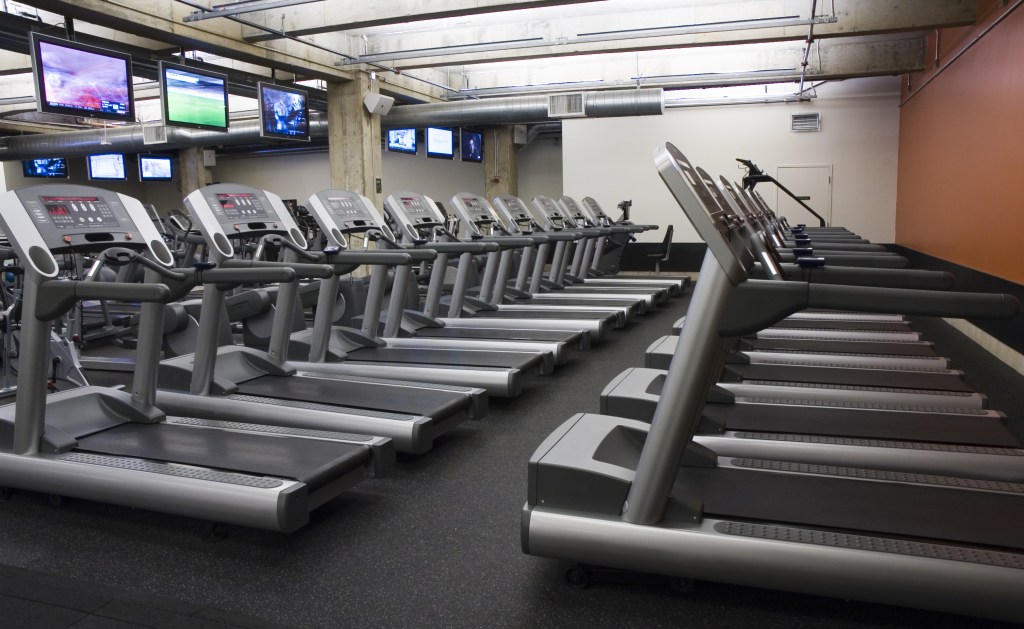 GettyImages-Rows of empty treadmills at an upscale health club.