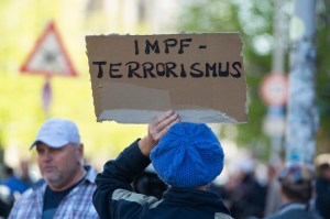 A woman holds a sign saying "vaccination terrorism" during an unauthorised demonstration on Rosa Luxemburg Place. In Berlin-Mitte, several hundred people participated in an unauthorized demonstration. Among the demonstrators were well-known conspiracy the