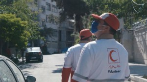 Members of Iran's Red Crescent Society distribute masks, gloves, and hand sanitizer to residents.