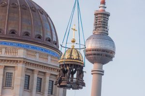 Ein goldenes Kreuz wird auf die Kuppel des Humboldt-Forums in Berlin montiert.