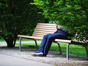 man sitting on a park bench using his smartphone