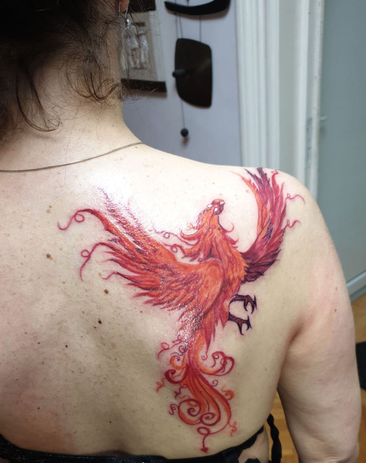 Ein großes Tattoo eines Phönix auf der rechten Schulter der Mutter der Autorin