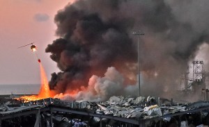 A helicopter fights a fire at the scene of an explosion at the port of Lebanon's capital Beirut on August 4, 2020.