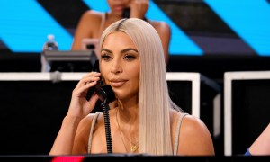 Kim Kardashian West with a phone pressed to her face.