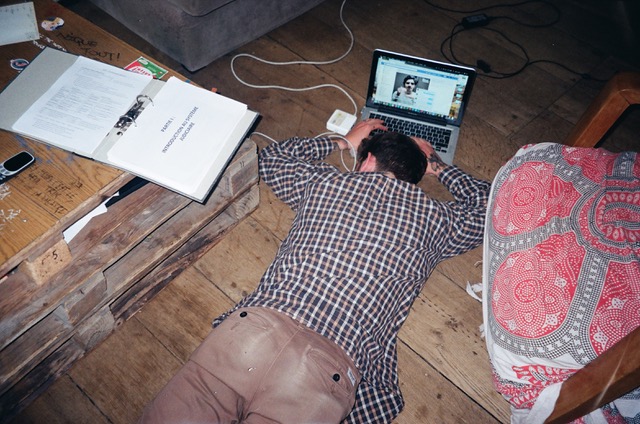 A guy passed out face down on the floor while typing on his laptop and doing a video call.