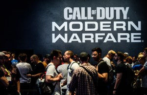 People gather in front of a 'Call of Duty: Modern Warfare' logo