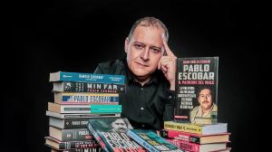 Sebastián Marroquín, der Sohn Pablob Escobars, sitzt hinter einem Stapel Bücher