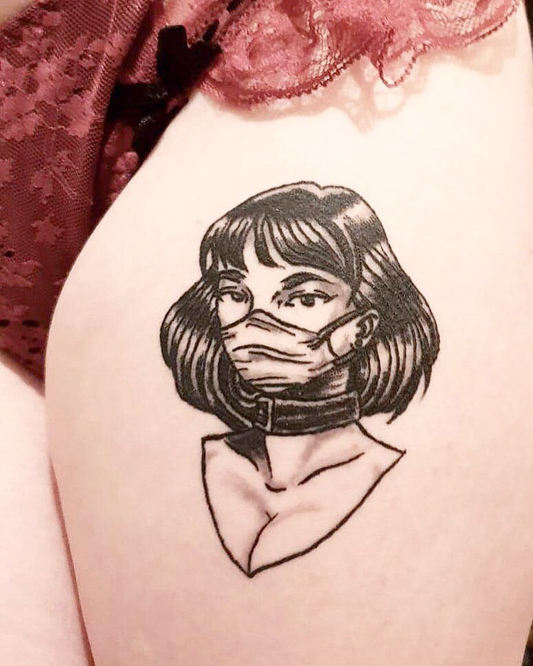 Das Tattoo zeigt eine junge Frau mit Mund-Nasen-Schutz