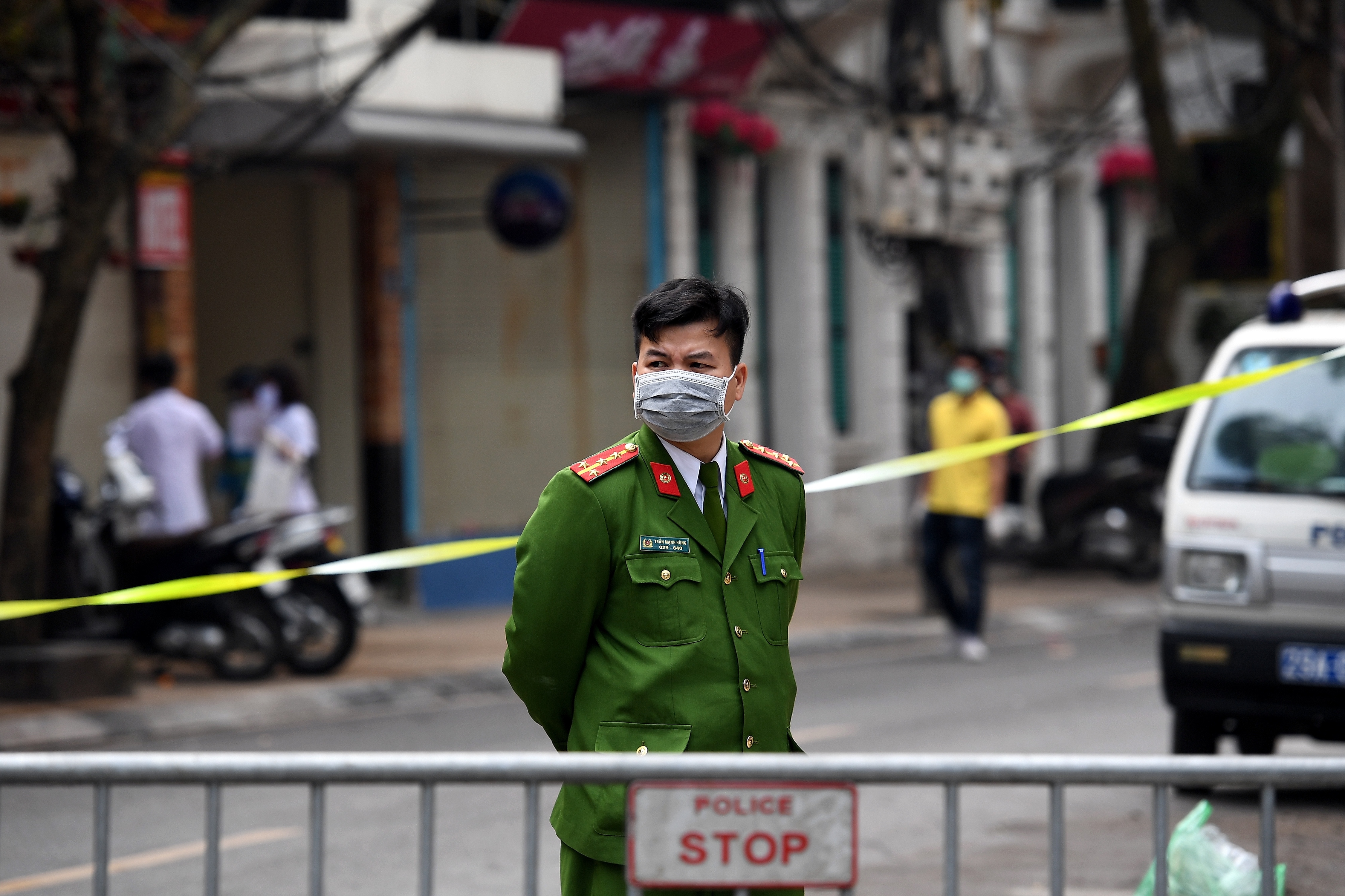A Vietnamese policeman stands guard at a makeshift checkpoint in the capital Hanoi. PHOTO: AFP / NHAC NGUYEN)