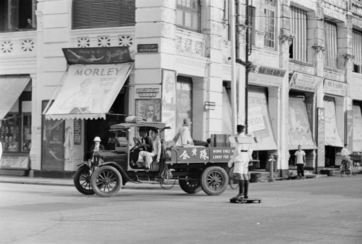 truck drives past traffic police with semaphore signal in 1940s singapore