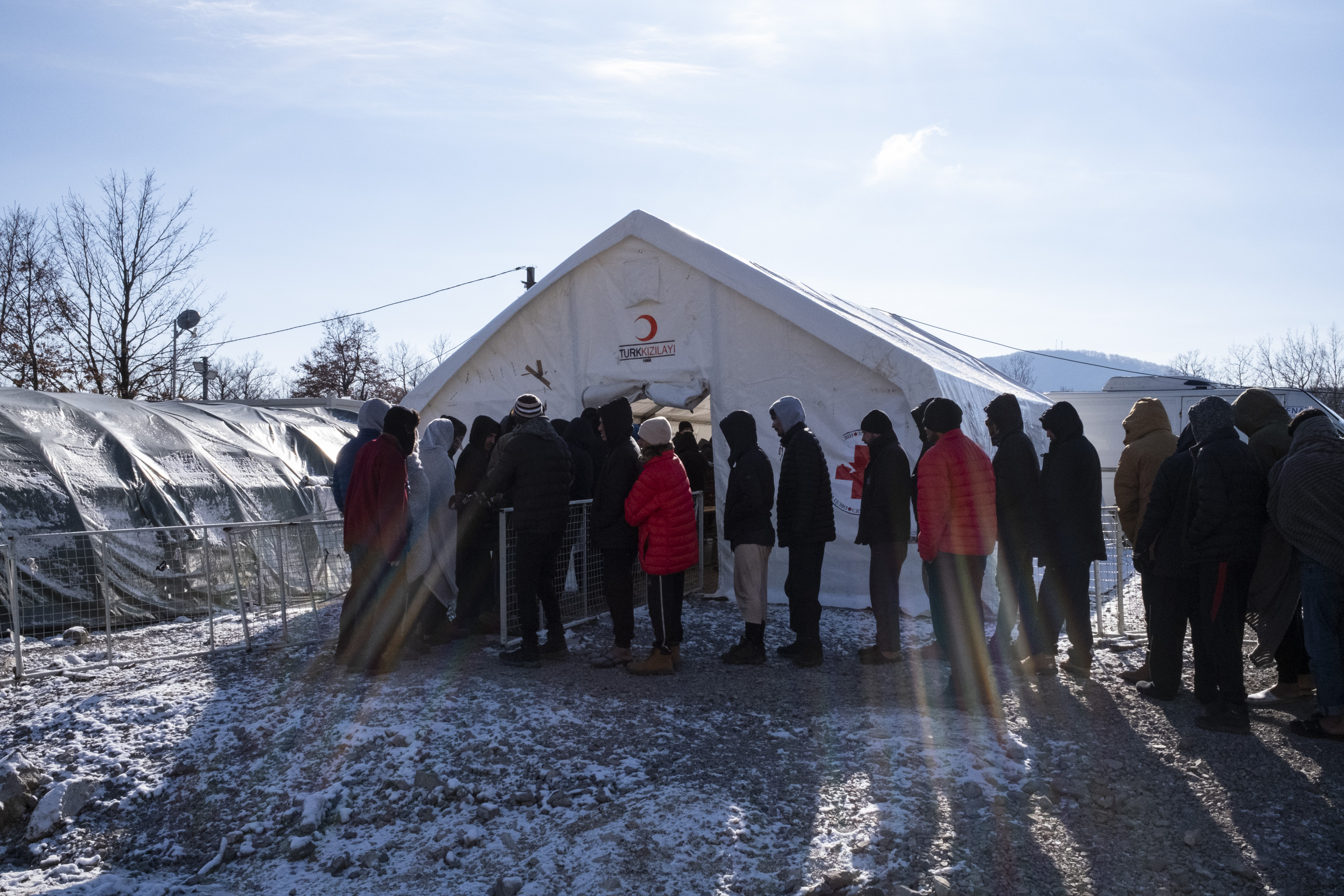 Migrants line up for food in the Lipa camp.