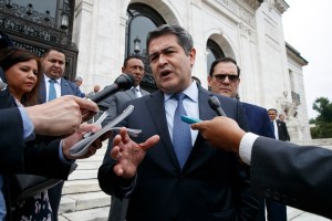 In this Aug. 13, 2019 file photo, Honduran President Juan Orlando Hernandez speaks to reporters as he leaves a meeting at the Organization of American States, in Washington. U.S.