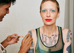 tattooed person getting vaccine injected in arm