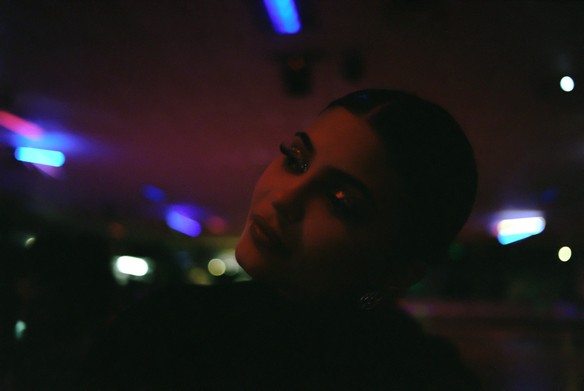 Kylie Jenner in a room with multi-colored lights.