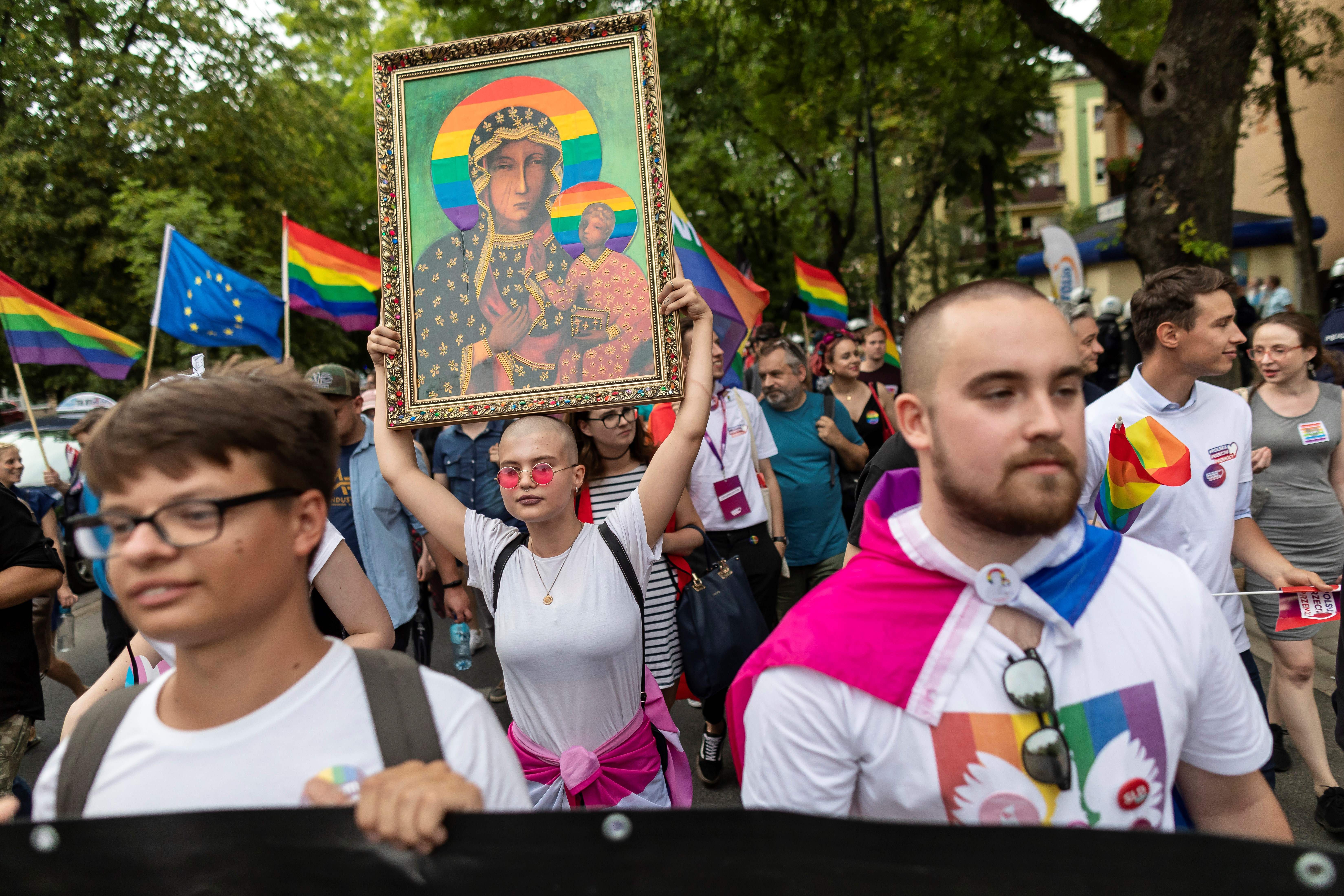 O protestatară ține o pancartă cu Fecioara Maria cu o aură curcubeu la o paradă Pride din Plock, în 2019. Fotografie: Wojtek Radwanski/AFP via Getty Images