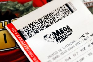 In this Oct. 17, 2018, file photo a Mega Millions lottery ticket rests on the shop counter at the Street Corner Market in Cincinnati.