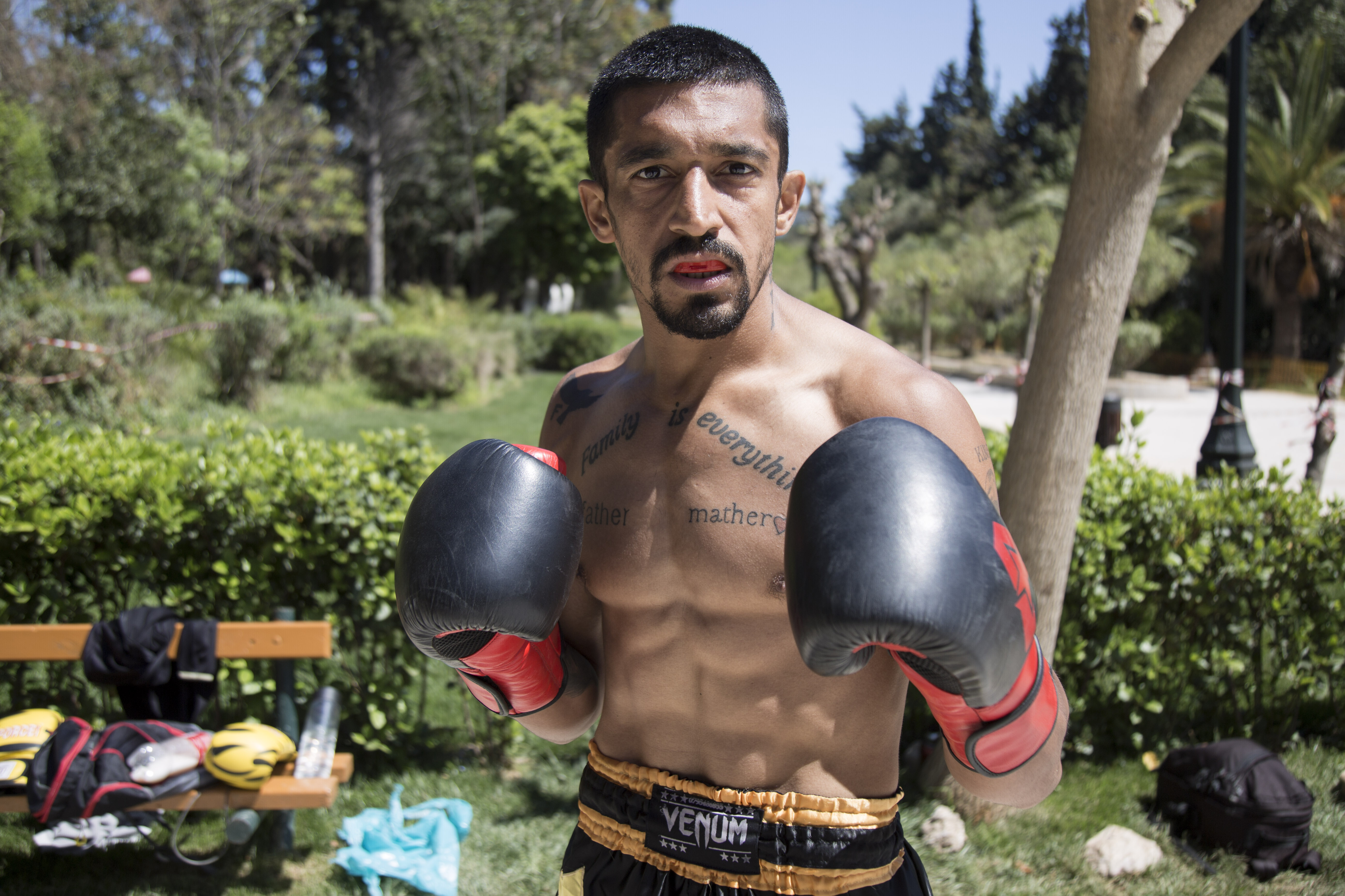 Ein muskulöser Mann posiert oben ohne und mit Boxhandschuhen für die Kamera